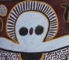 Detail of a Wandjina face: large dark eyes, no mouth, and a radiating halo