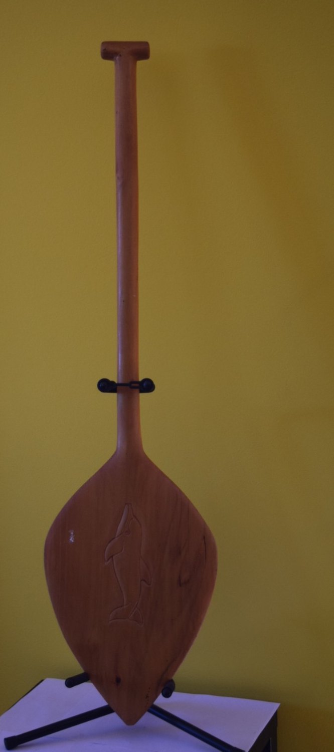 A Palauan canoe paddle with a leaf-shaped blade and an incised dolphin
